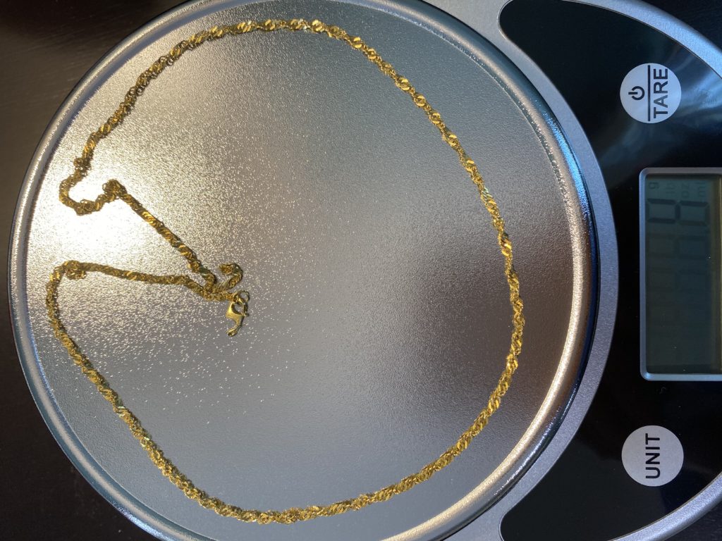 A gold chain is sitting on top of a pan.